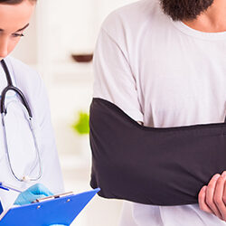 A doctor helping a man with a broken arm