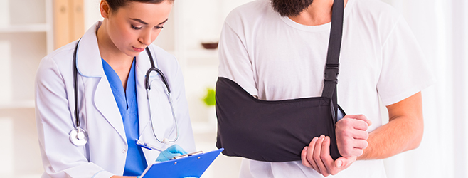 A doctor helping a man with a broken arm